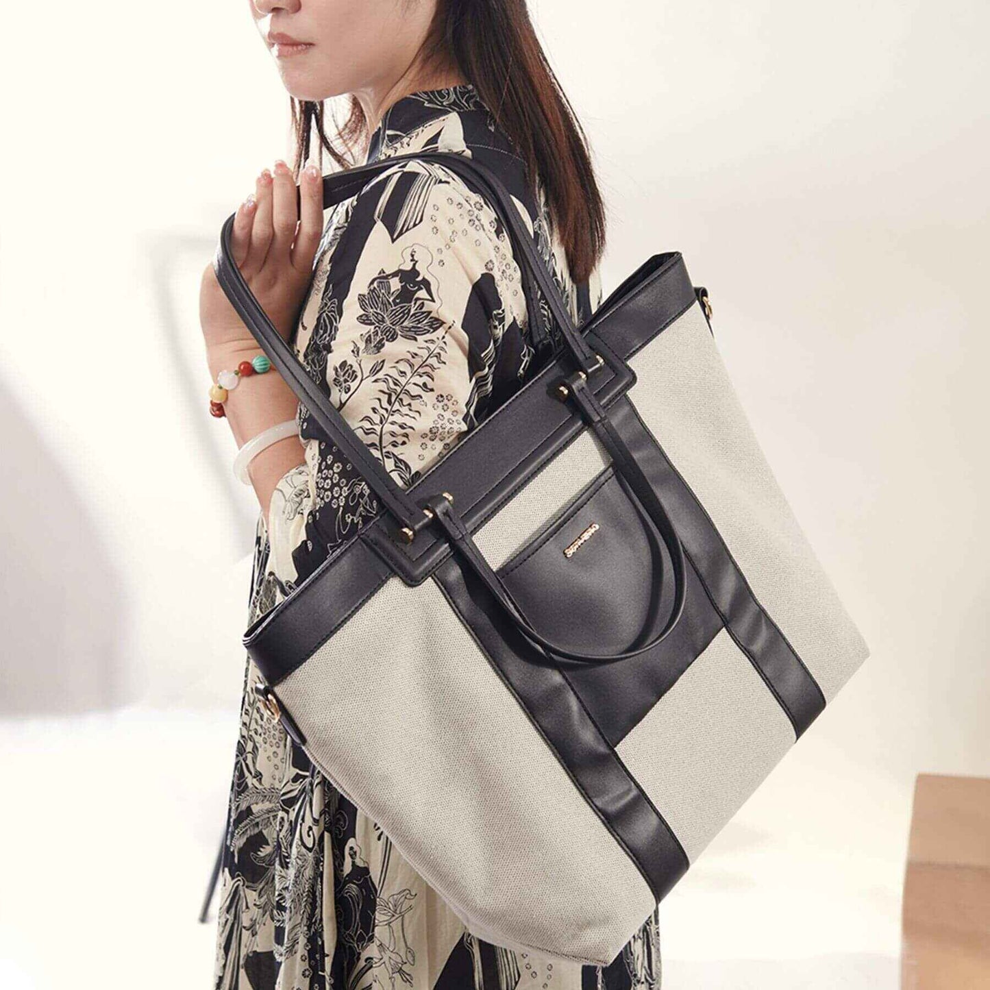 Woman holding Sunveno The Mommy Tote Bag - Black against a neutral background