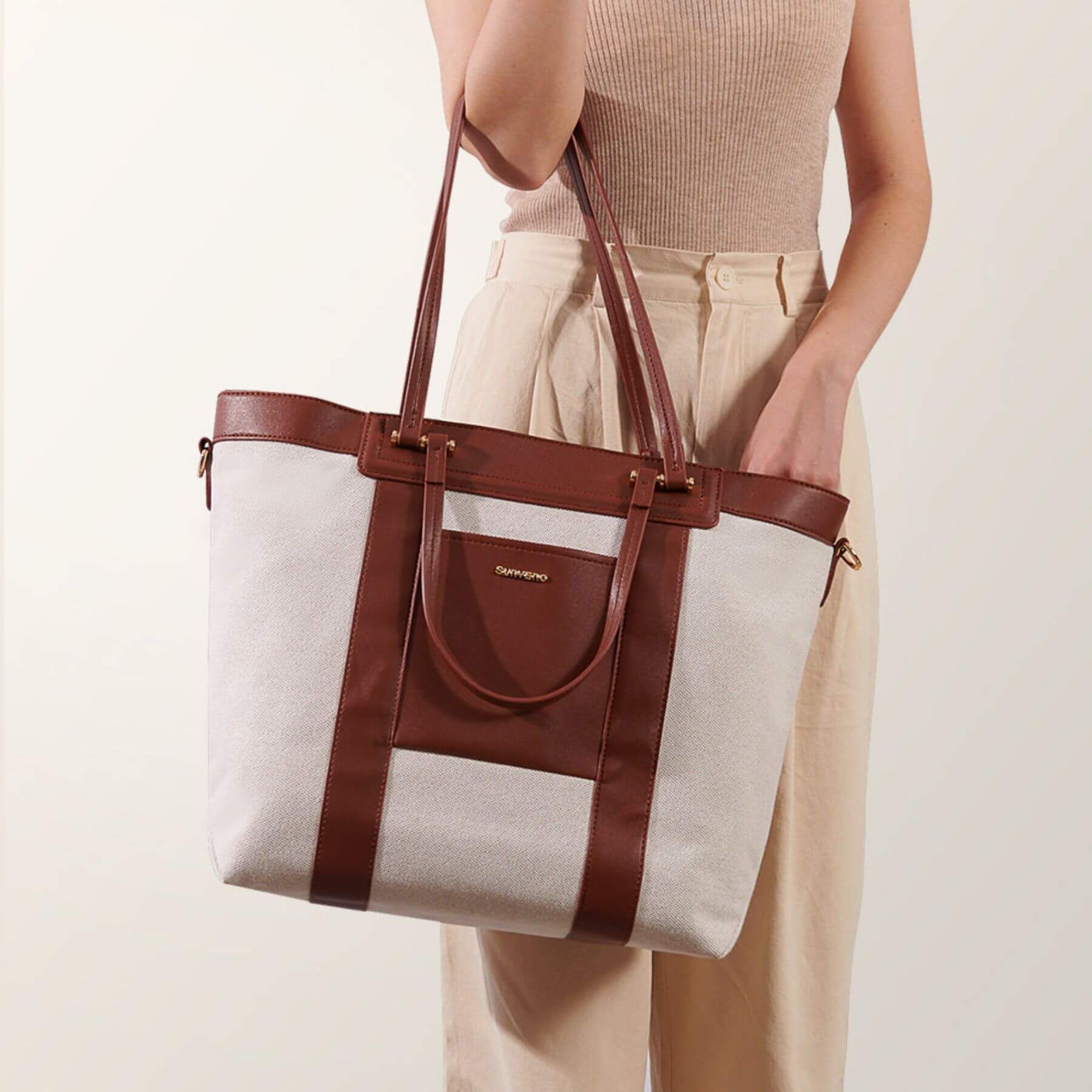 Person holding Sunveno The Mommy Tote Bag - Brown on a plain background
