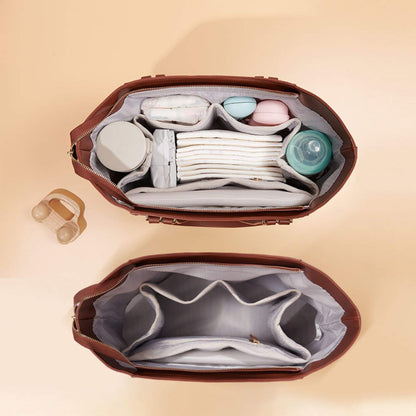 Open Sunveno The Mommy Tote Bag - Brown with baby items on a beige background