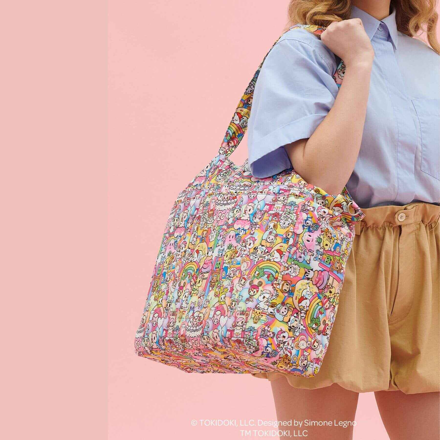 Person holding tokidoki Super Be Diaper Bag Tote against a pink background