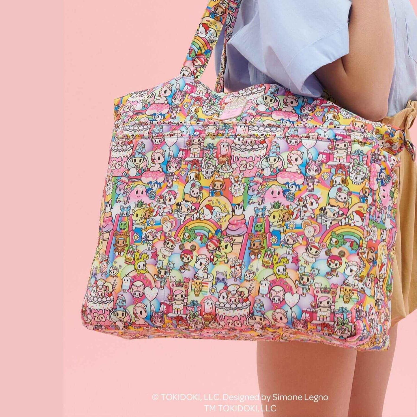 tokidoki Super Be Diaper Bag Tote held by a person on a pink background