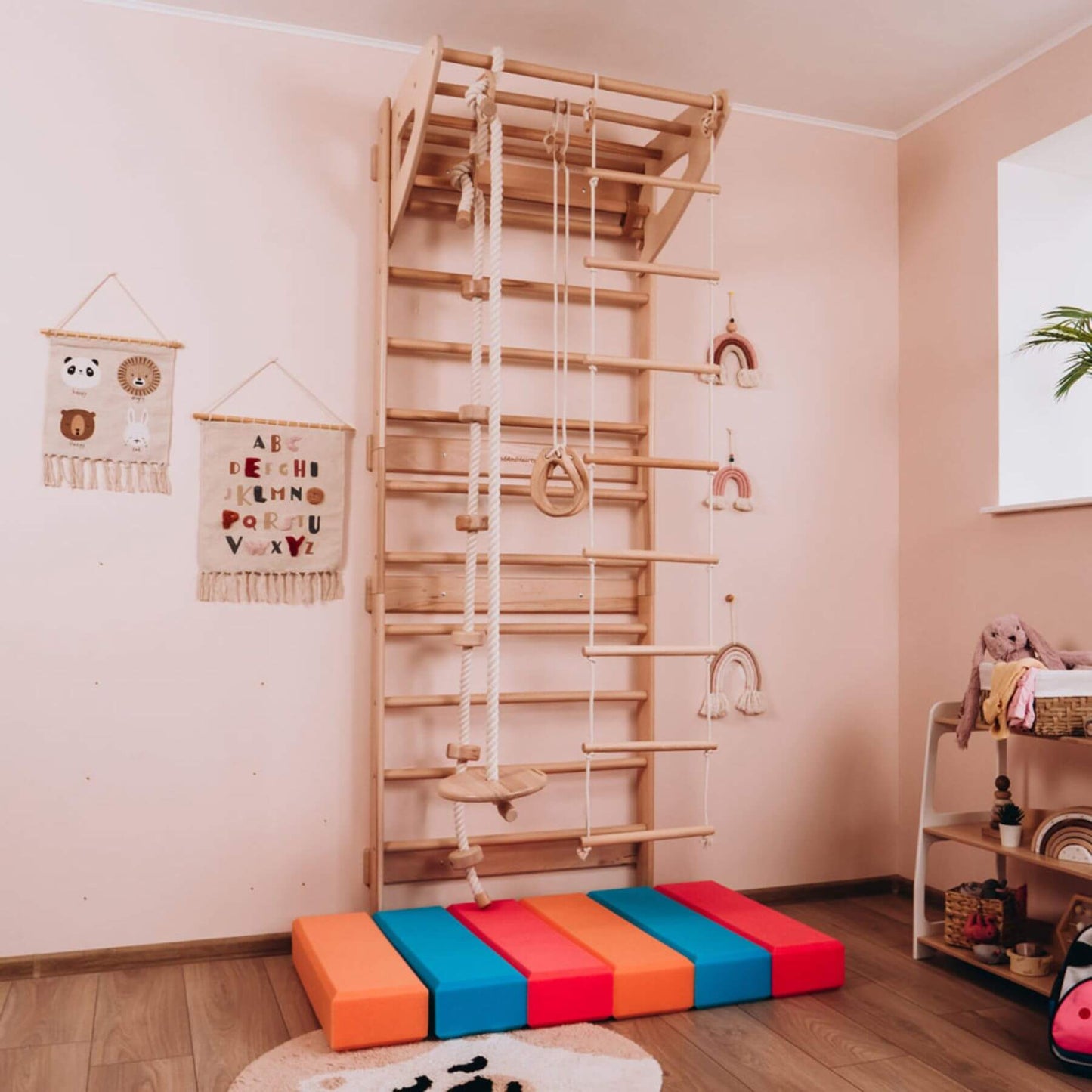 Children's play area with Wood and Hearts Swedish Ladder Gym on a wooden floor.