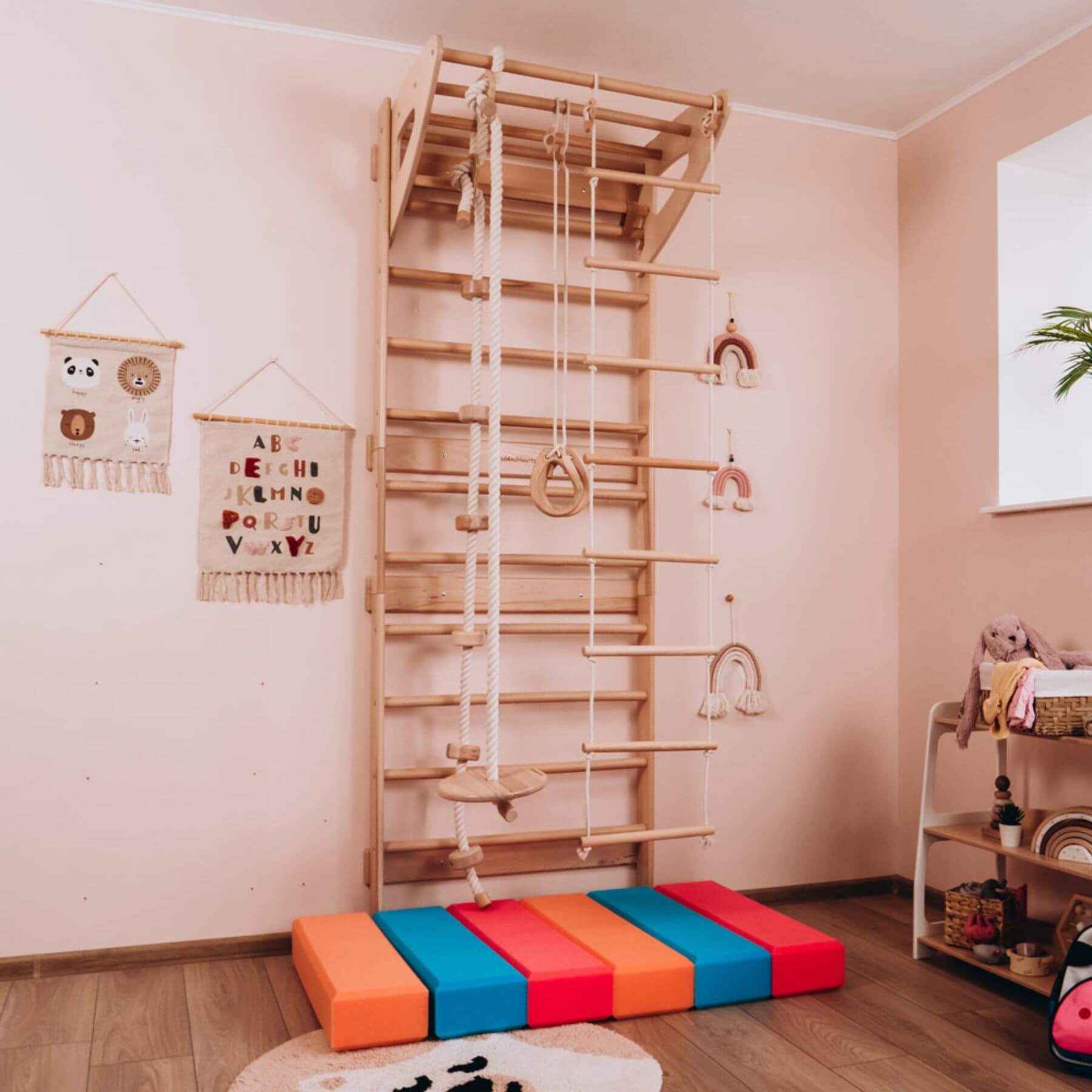 Children's play area with Wood and Hearts Swedish Ladder Gym on a wooden floor.