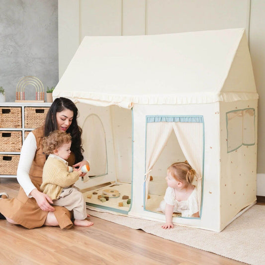 Woman and child playing inside Tiny Land® Sweet Citrus Kid's Play Tent - Creamy white/blue in a room with wooden floor and shelves.