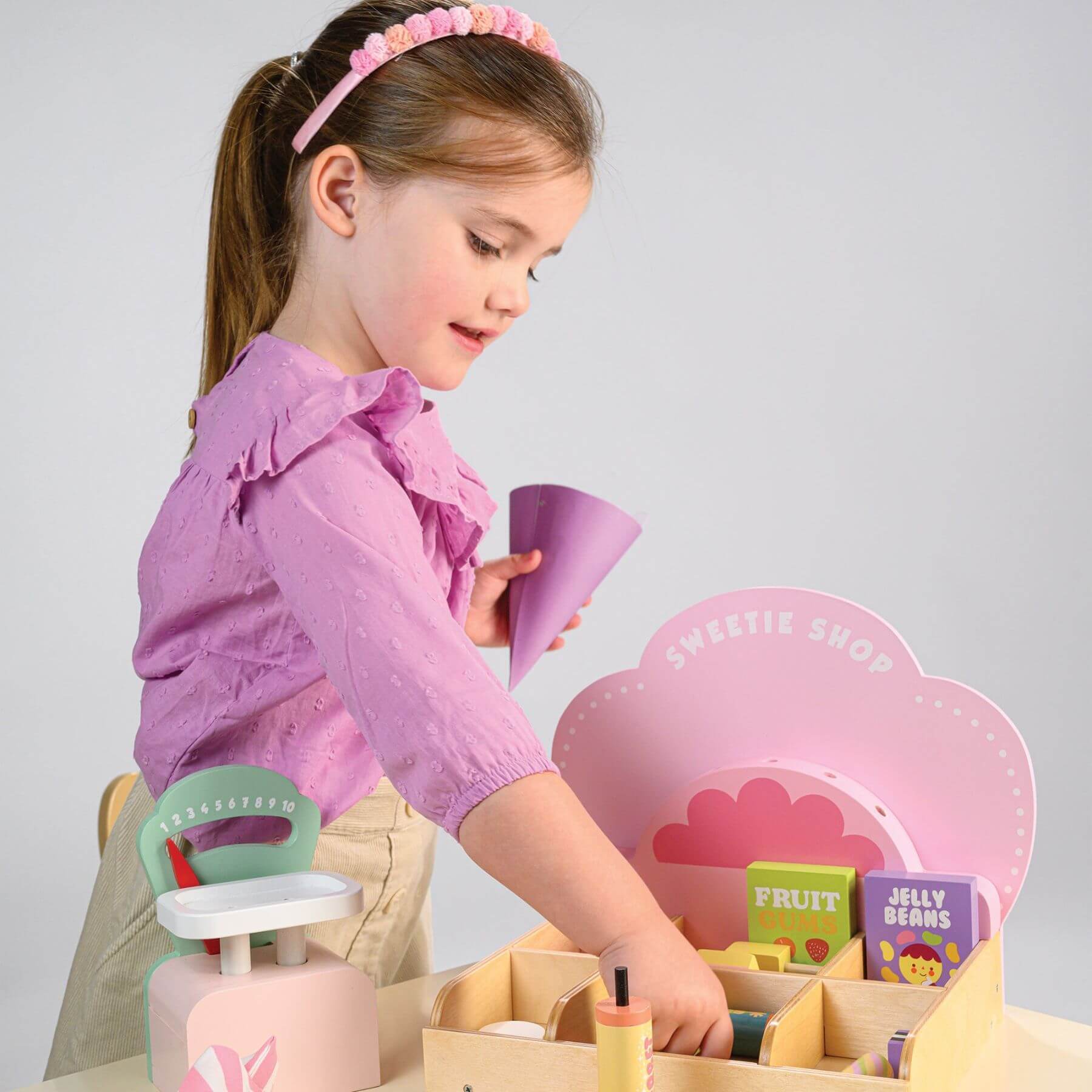 Child playing with Tender Leaf Sweetie Pic'n'Mix Shop on a light gray background