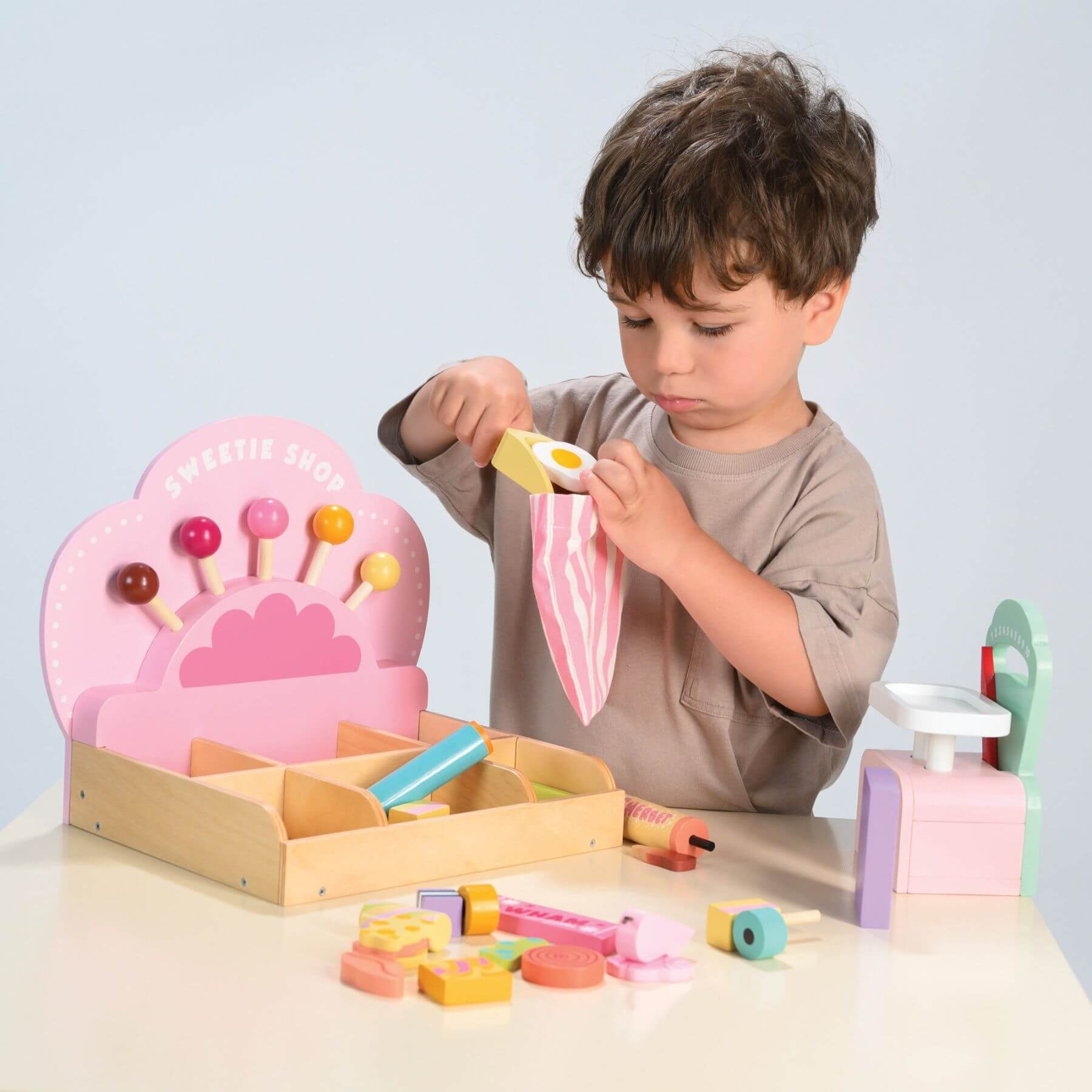 Child playing with Tender Leaf Sweetie Pic'n'Mix Shop on a light gray background