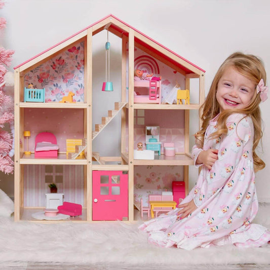 Girl Sitting next to Tiny Land® Sweetwood Love Dollhouse