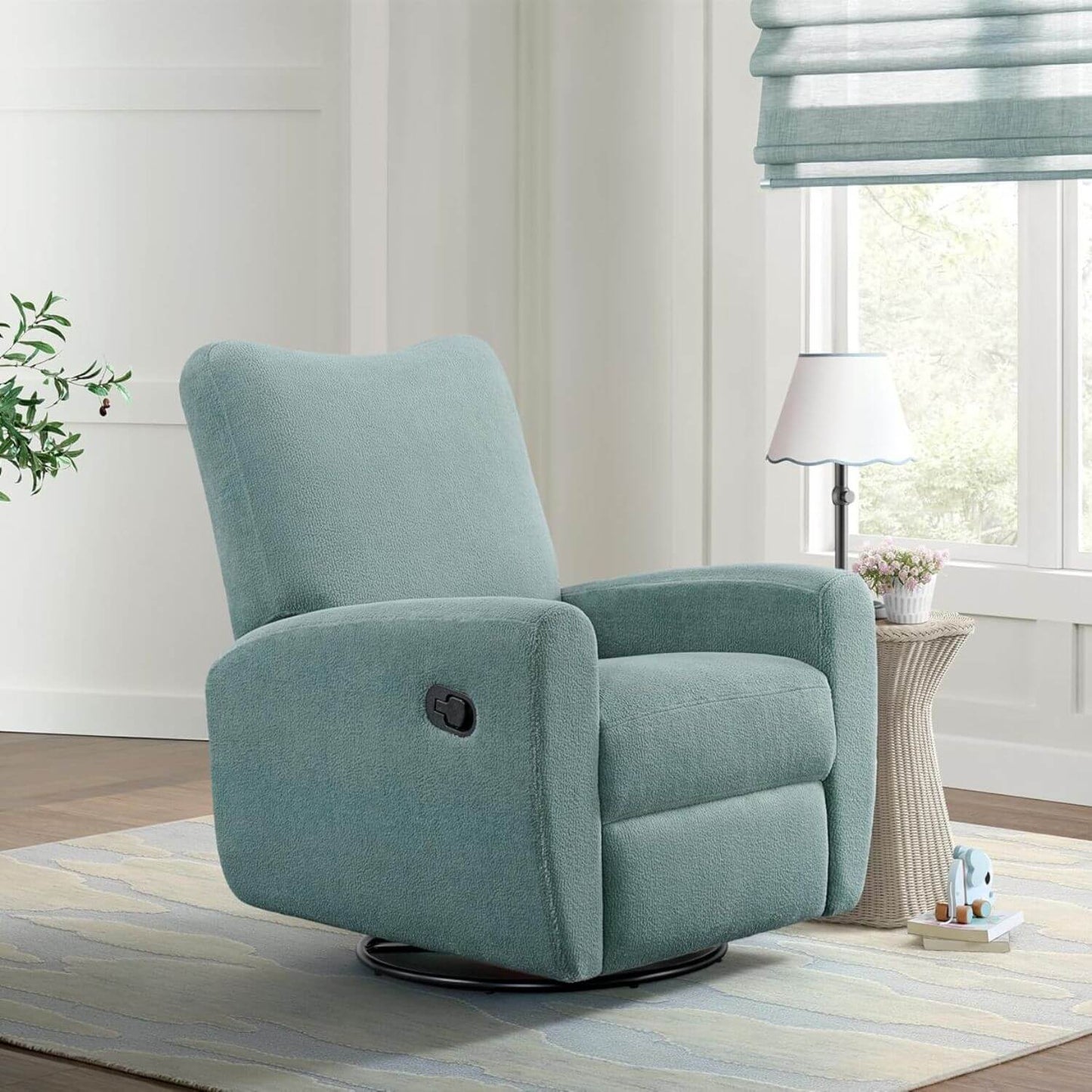 Oxford Baby Synergy Glider - Teal Mist in a living room setting with a lamp and window in the background.