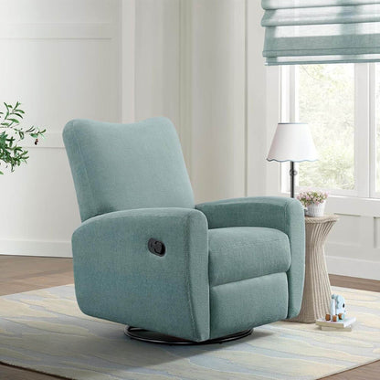 Oxford Baby Synergy Glider - Teal Mist in a living room setting with a lamp and window in the background.