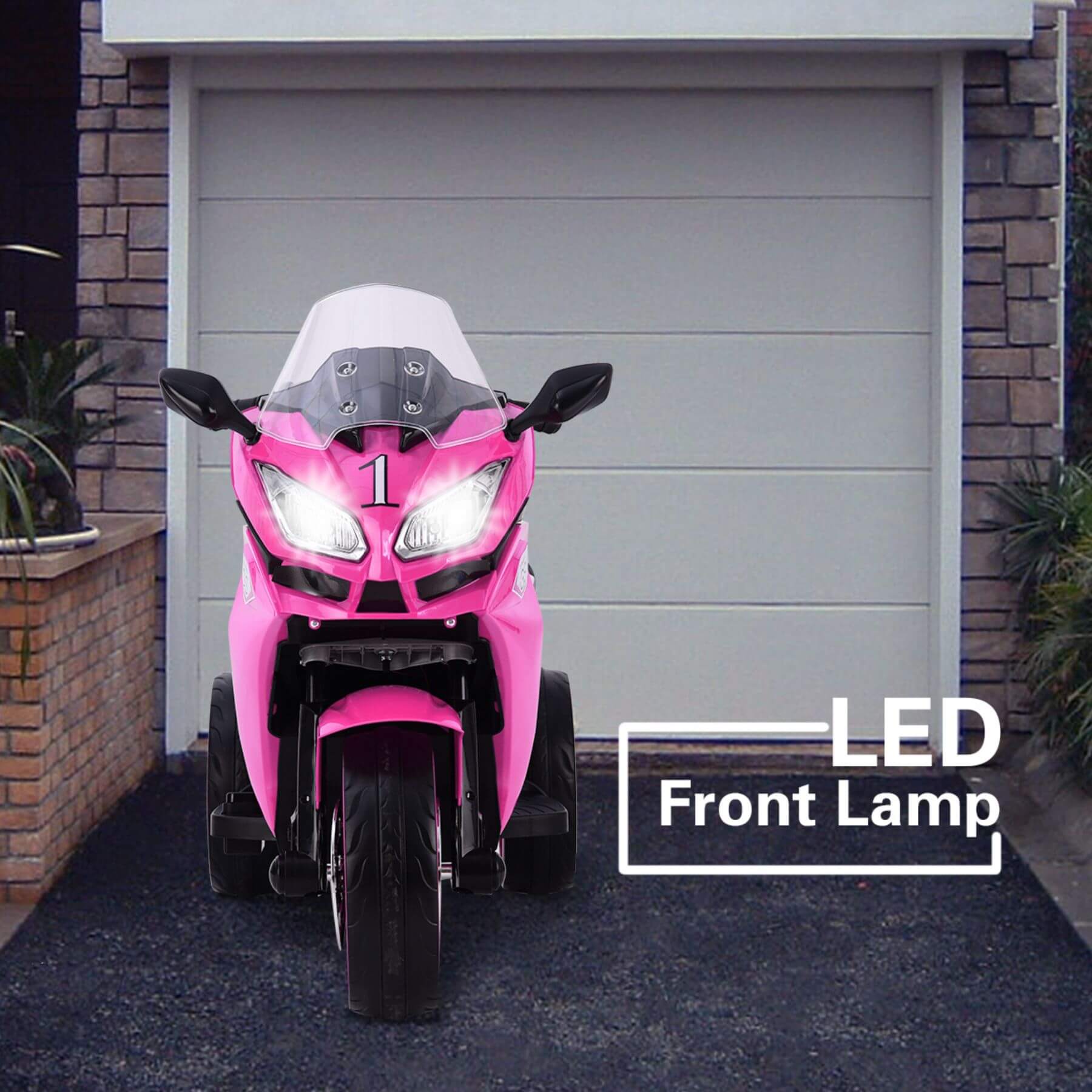 Tamco 12V Kids Electric Ride On Motorcycle - Pink in front of a garage.