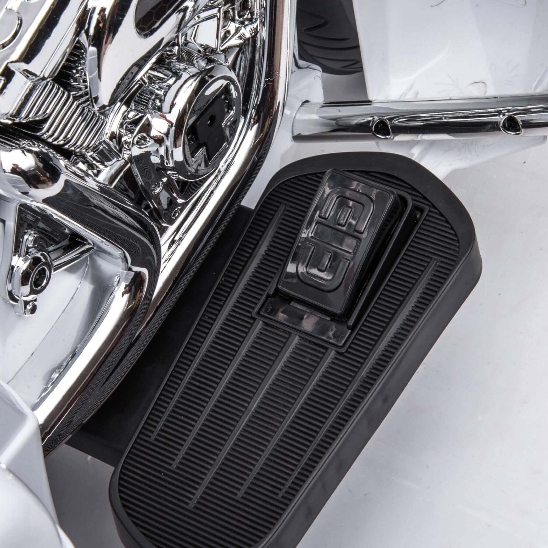 Close-up of a motorcycle foot peg with chrome engine in the background