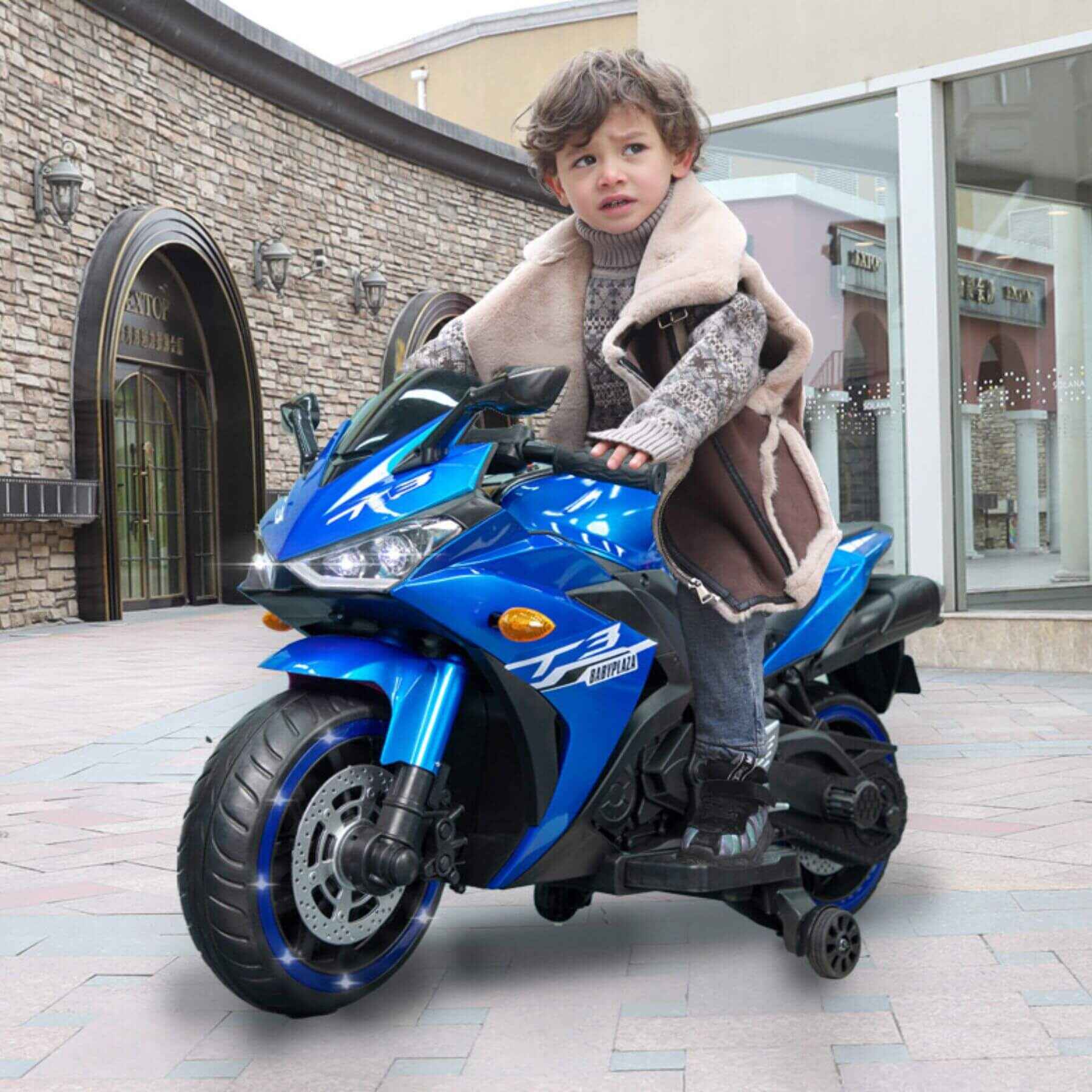 Child sitting on Tamco Kids 12V Motorcycle with Training Wheels - Blue in an outdoor setting