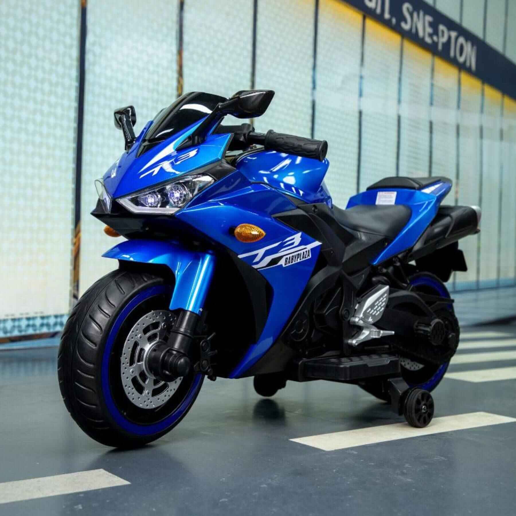 Tamco Kids 12V Motorcycle with Training Wheels - Blue on a gray floor with a blurred background