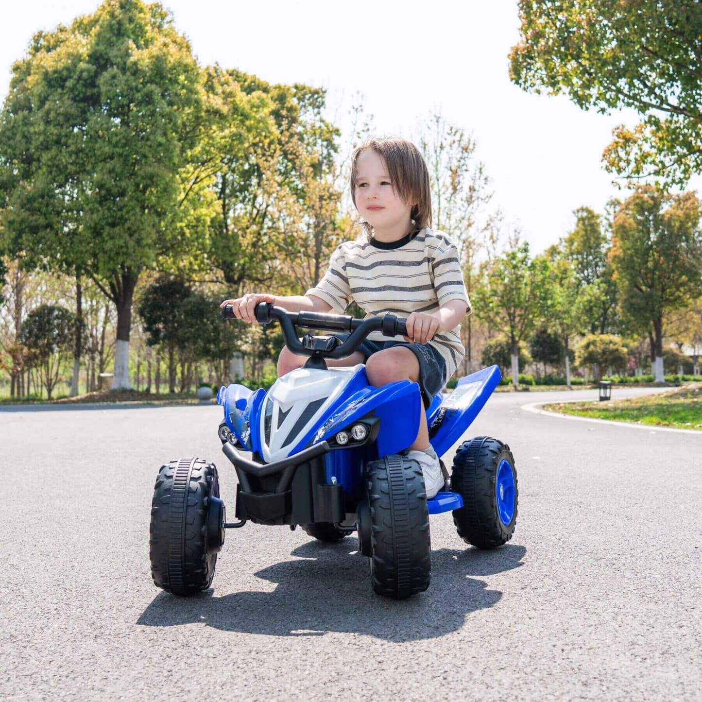Child riding Tamco Kids Dual Motor Electric Ride On Toy - Blue on a road with trees in the background