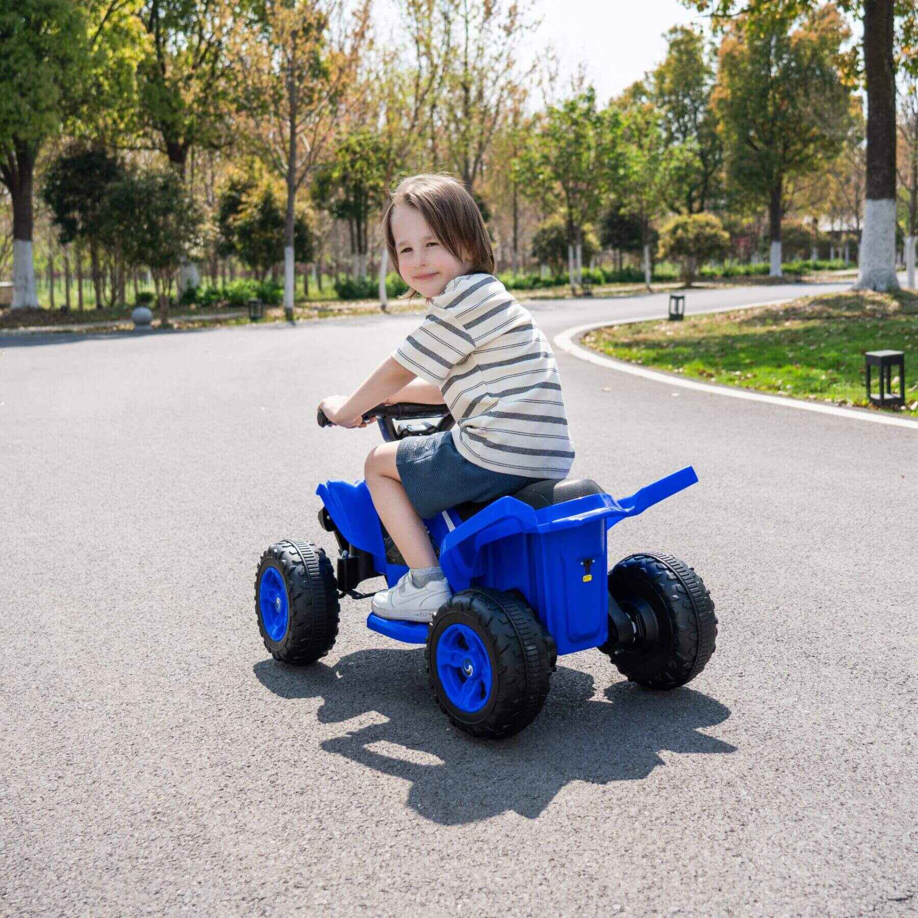 Child riding Tamco Kids Dual Motor Electric Ride On Toy - Blue on a paved road with trees in the background