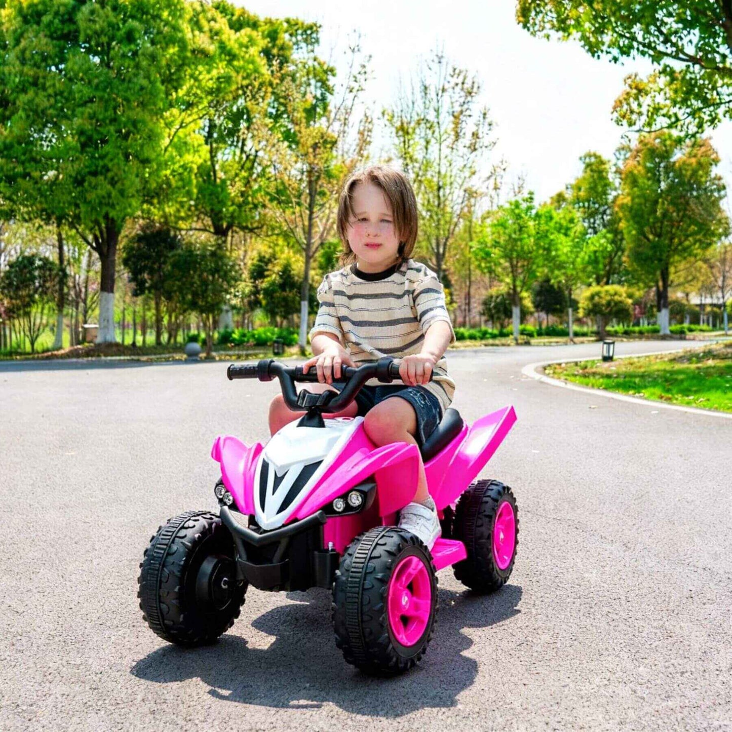 Child riding Tamco Kids Dual Motor Electric Ride On Toy - Pink on a sunny day in a park.