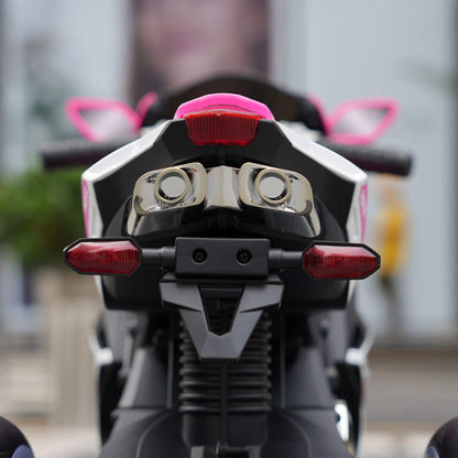 Close-up of Child sitting on Tamco 6V Kids Electric Motorcycle - Pink with blurred background