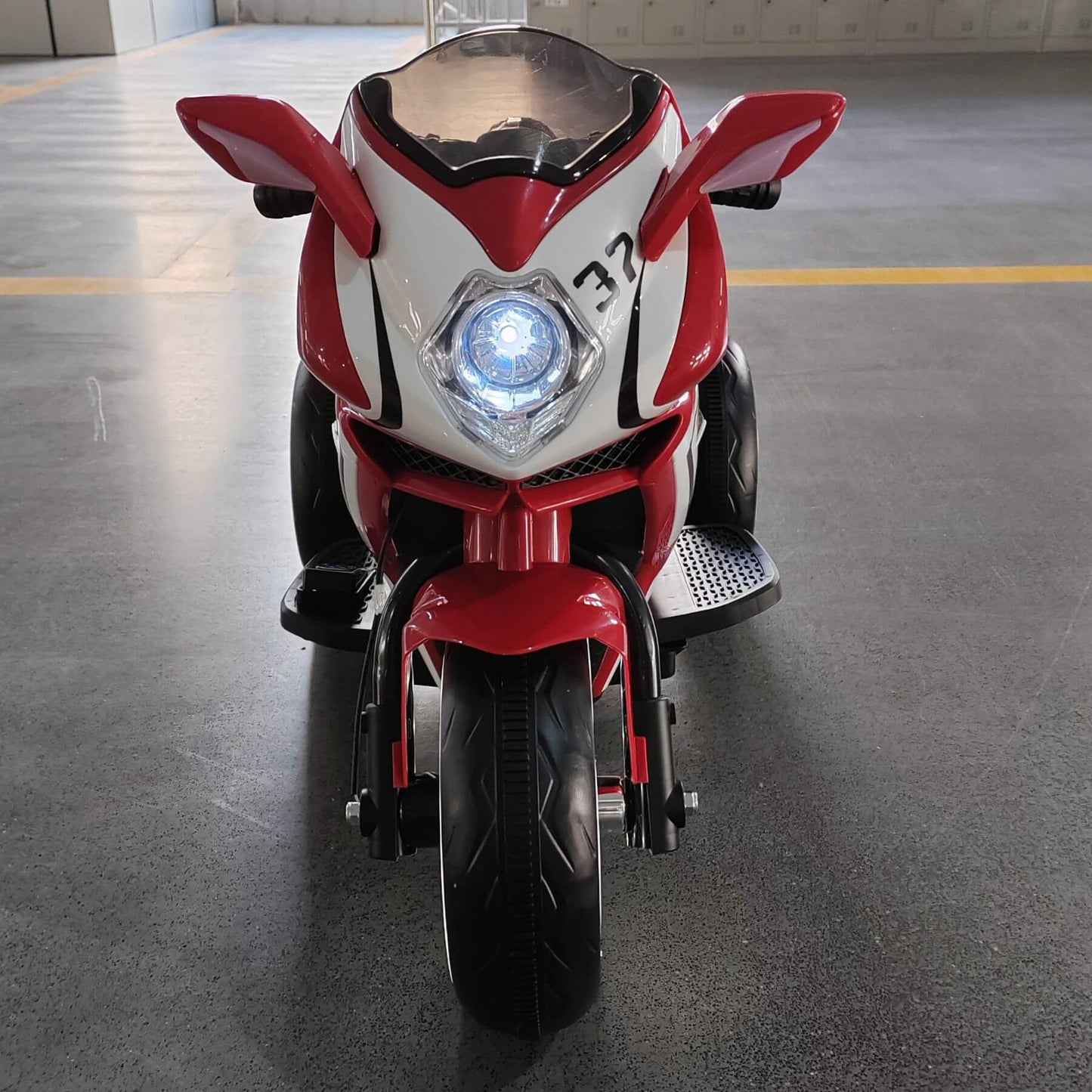 Tamco 6V Kids Electric Motorcycle - Red on a gray floor.