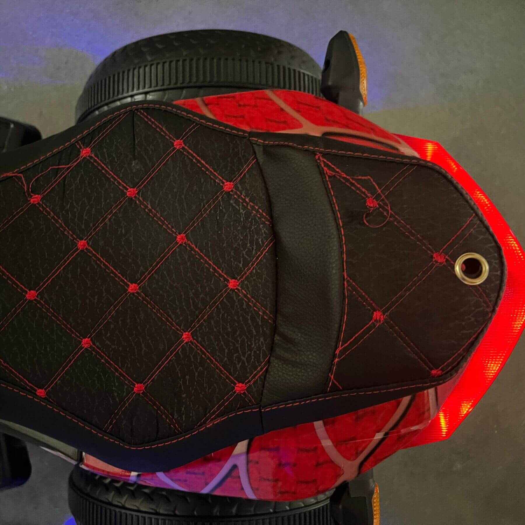 Close-up of a red and black motorcycle seat with quilted design
