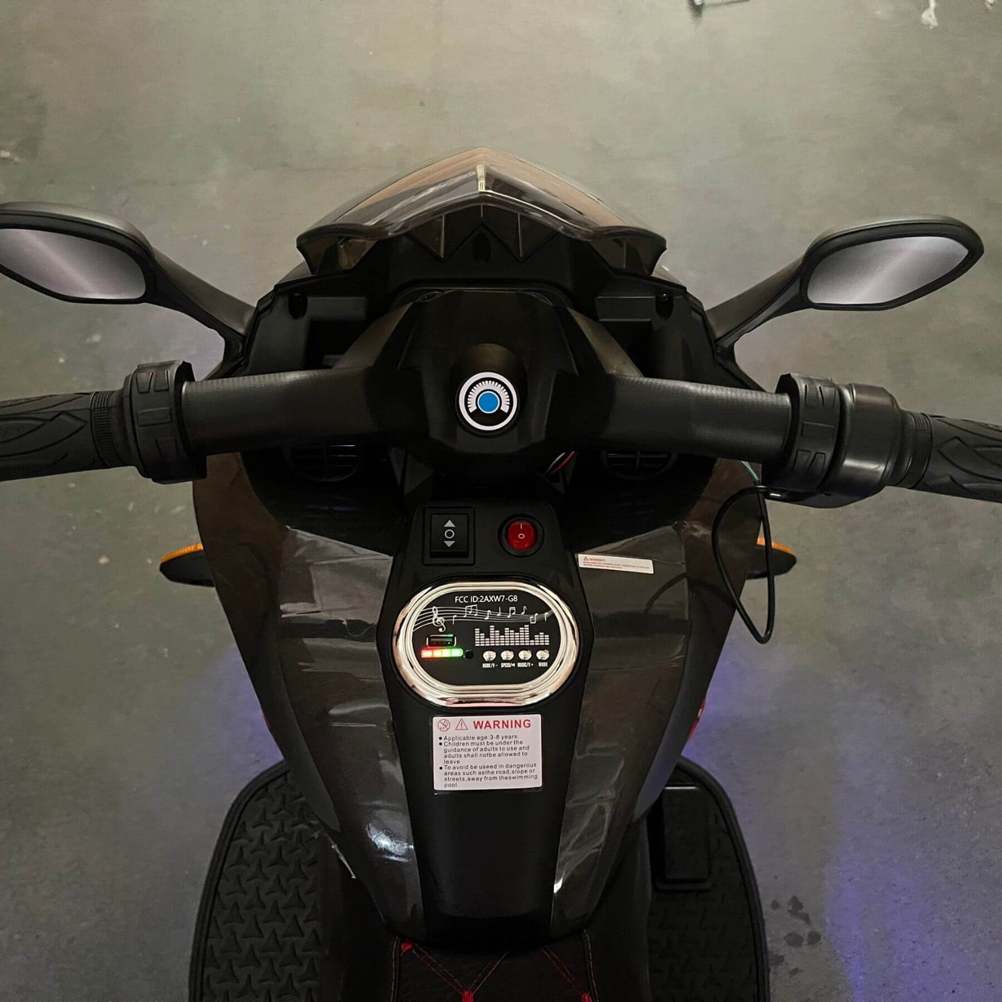 Close-up of a motorcycle's handlebar and dashboard against a gray background