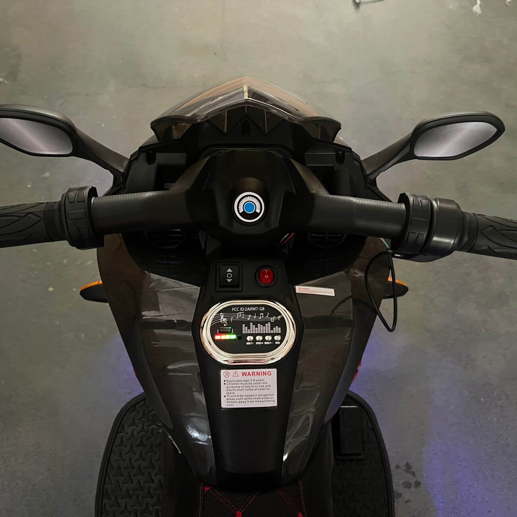 Close-up of a motorcycle's handlebar and dashboard on a gray background