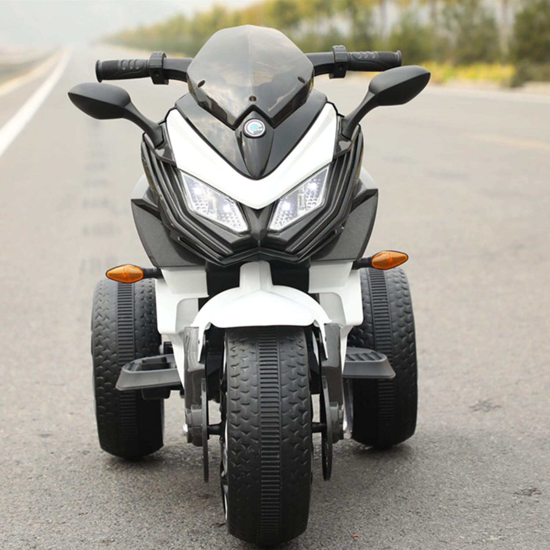 Tamco Kids Motorcycle Ride-On 3-Wheels Battery Powered Motorbike - White on a road with a blurred background