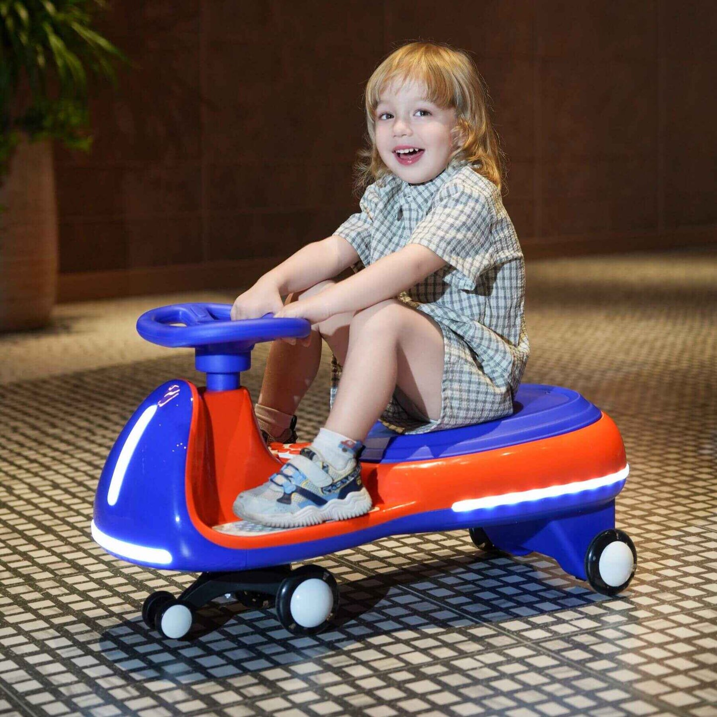 Child sitting on Tamco 12V Battery Electric Twist Car on a tiled floor.