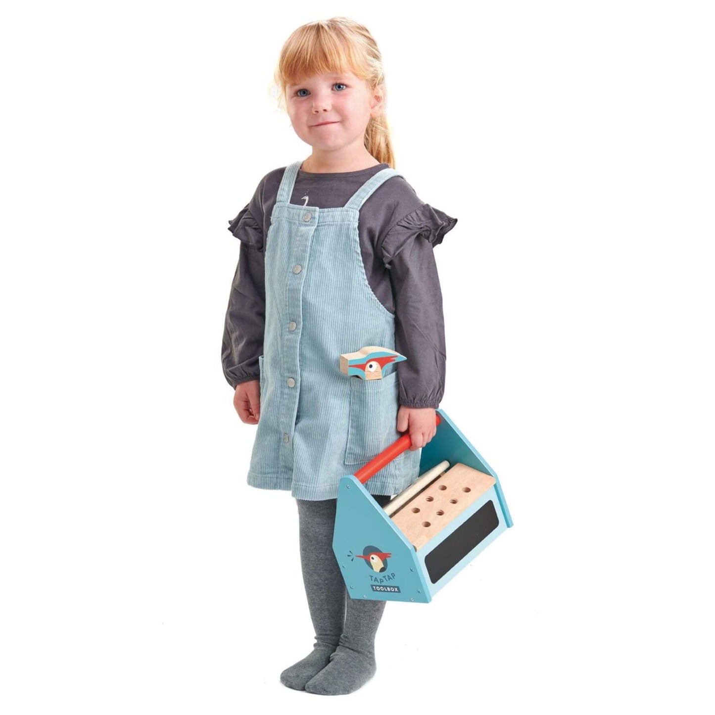 Child wearing a denim apron holding Tender Leaf Tap Tap Tool Box