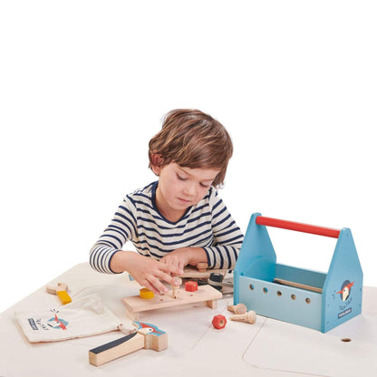 Child playing with Tender Leaf Tap Tap Tool Box on a white surface