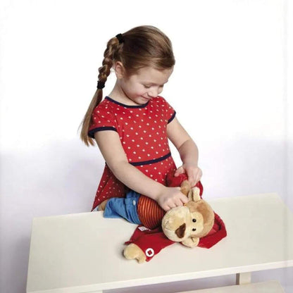 Child playing with sigikid Teaching Monkey on a white surface