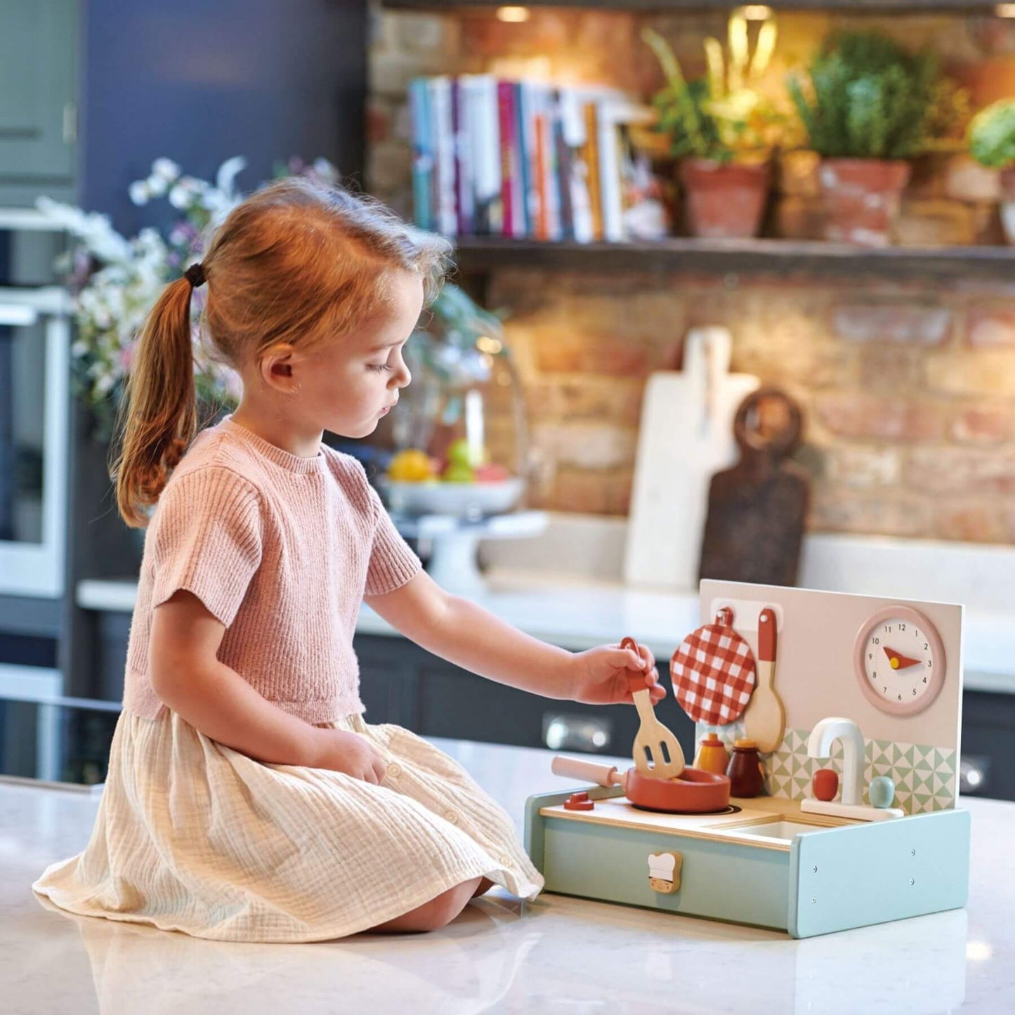 Child playing with Tender Leaf Kitchenette in a kitchen setting