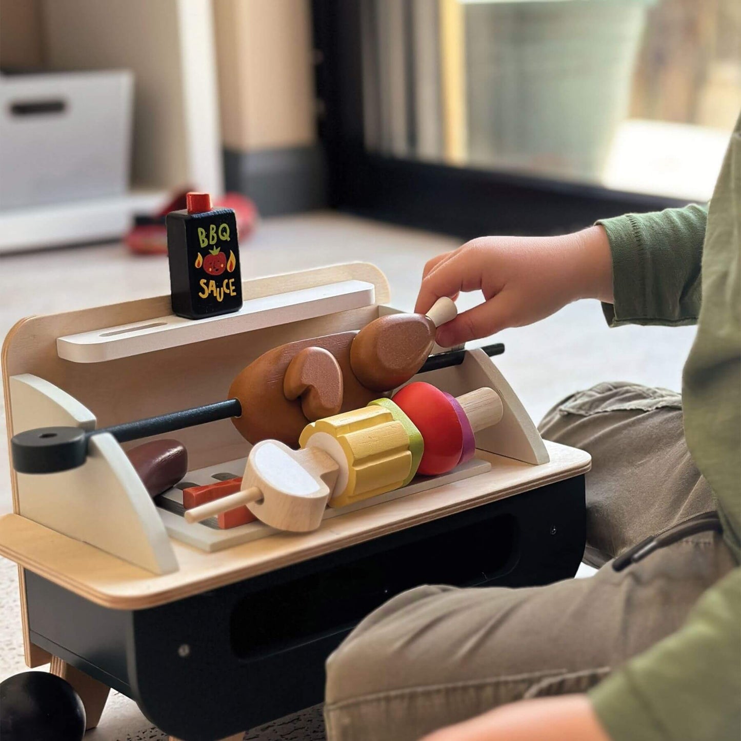 Child playing with Tender Leaf Barbeque Play Set on a table.