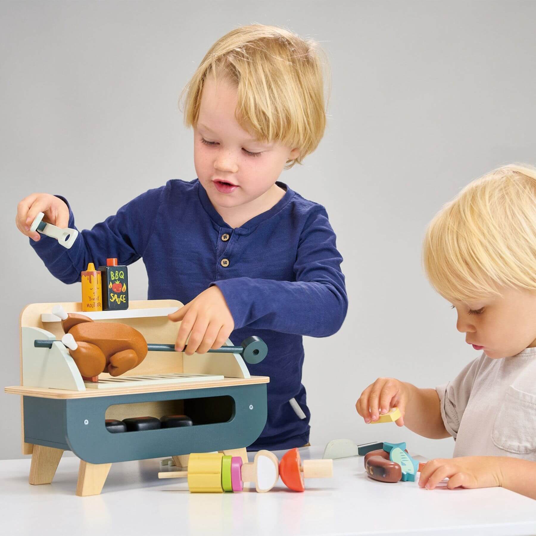 Two children playing with Tender Leaf Barbeque Play Set