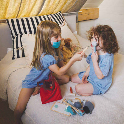 Two children playing with toys on a bed in a cozy room.