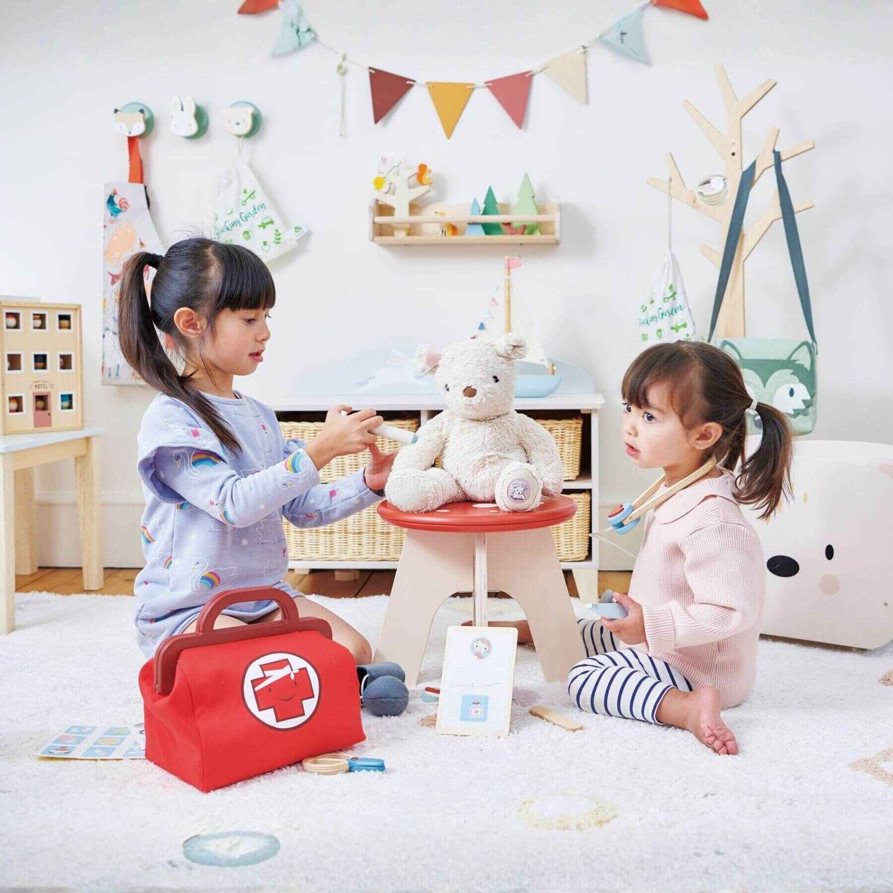 Two children playing with toys in a room with colorful decorations.