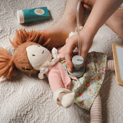 Child playing with a doll and fairy light on a soft surface