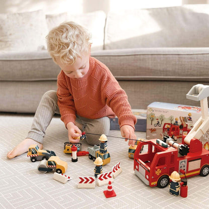 Child playing with Tender Leaf Fire Engine on a tiled floor.