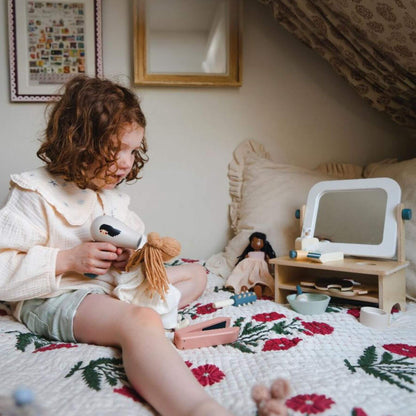 Child playing with Tender Leaf Hair Salon on a bed in a bedroom
