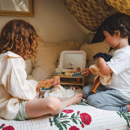 Two children playing with Tender Leaf Hair Salon on a bed in a cozy room.