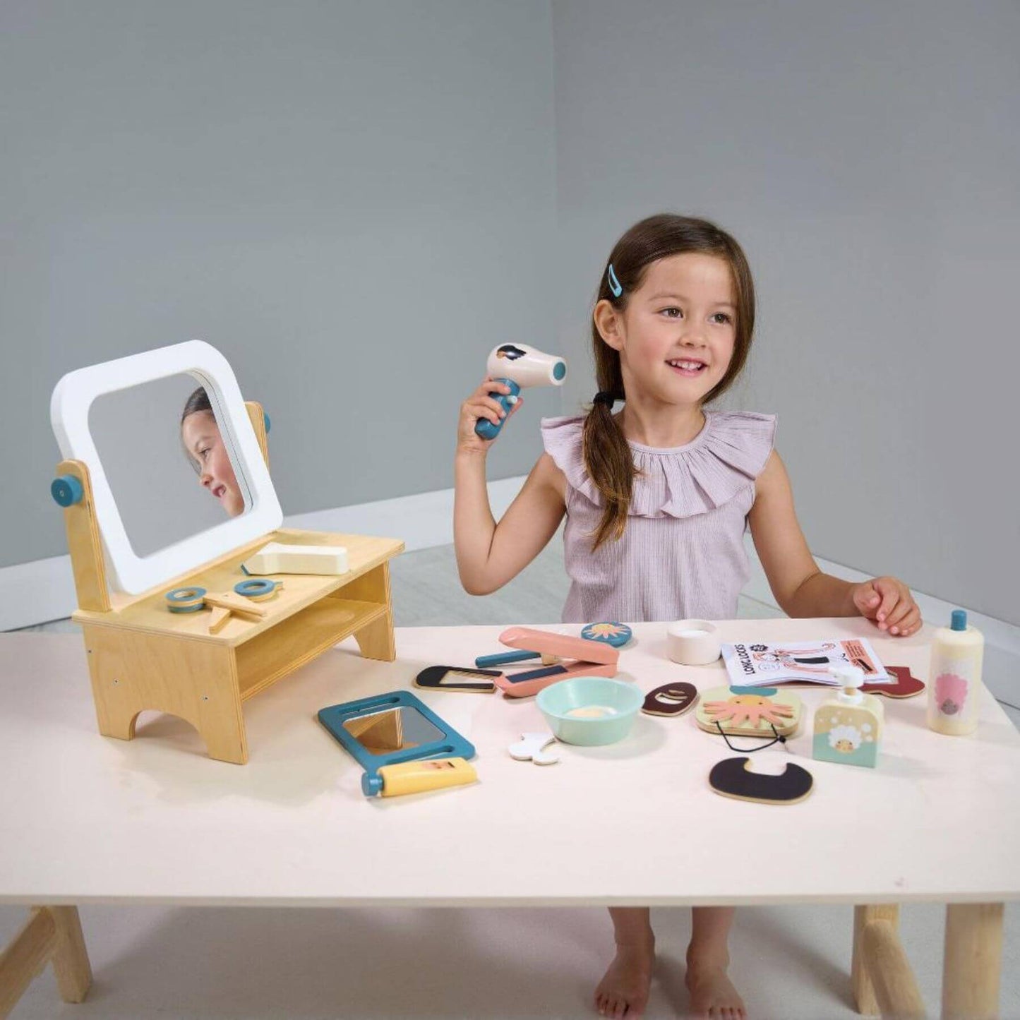 Young girl playing with Tender Leaf Hair Salon on a table