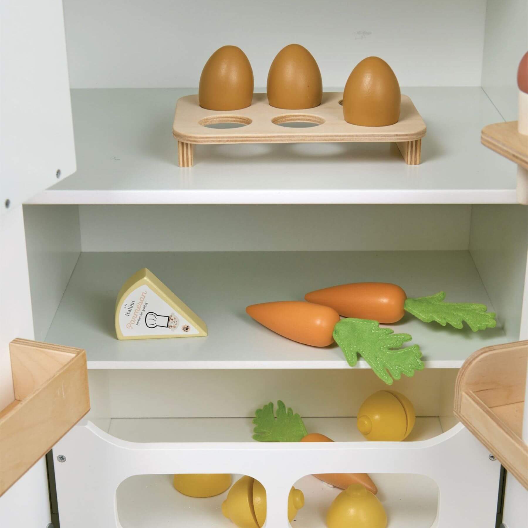 Wooden toy set with eggs, carrots, and cheese on a white shelf