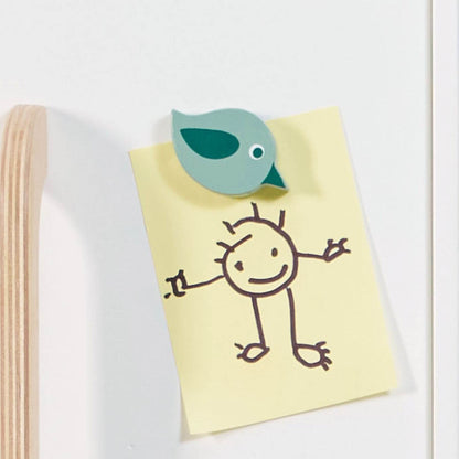 Notebook with a stick figure drawing and a green bird-shaped object on Tender Leaf Refrigerator