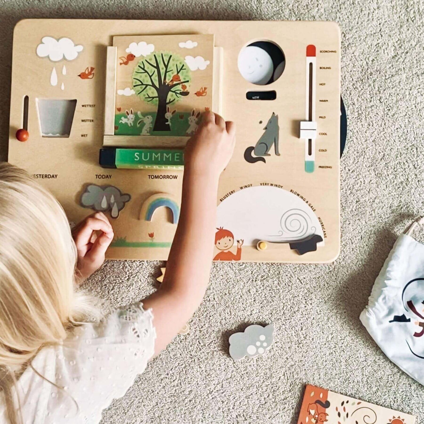 Child playing with Tender Leaf Weather Watch on a carpeted floor