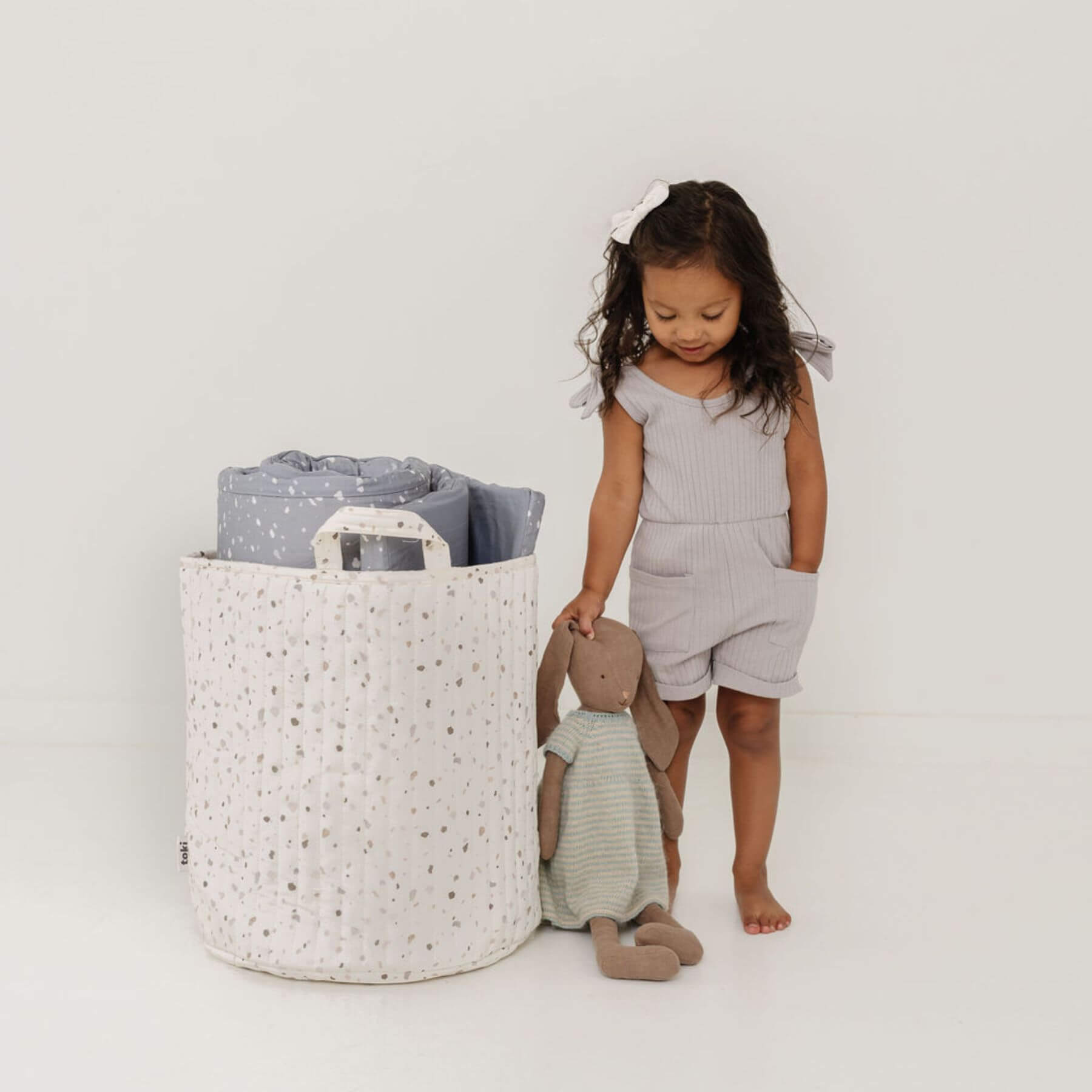 Child playing with a toy next to Terrazzo Chalk Storage Basket