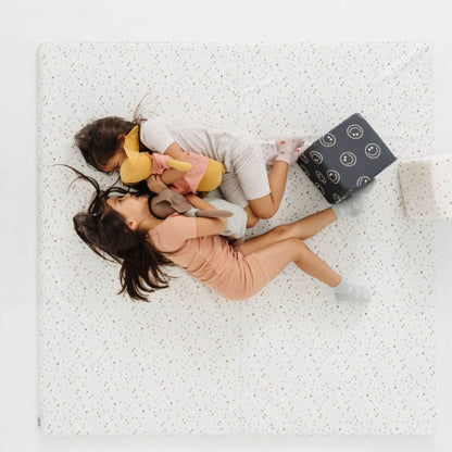 Two Girls lying on Toki Kids Terrazzo Chalk Vegan Leather Mat