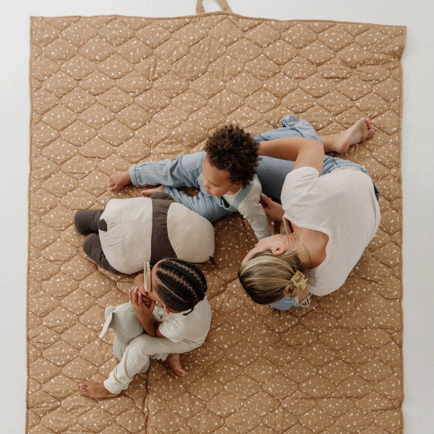 Three children sitting on Toki Kids Terrazzo Clay Picnic Blanket