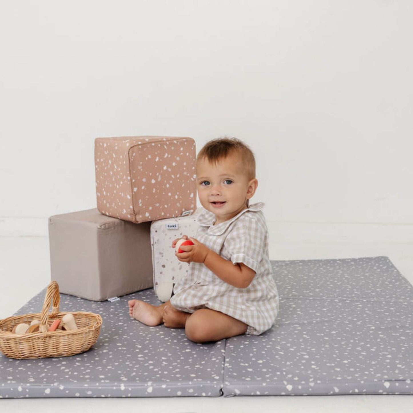 Baby sitting on play mat with Toki Kids Play Cubes