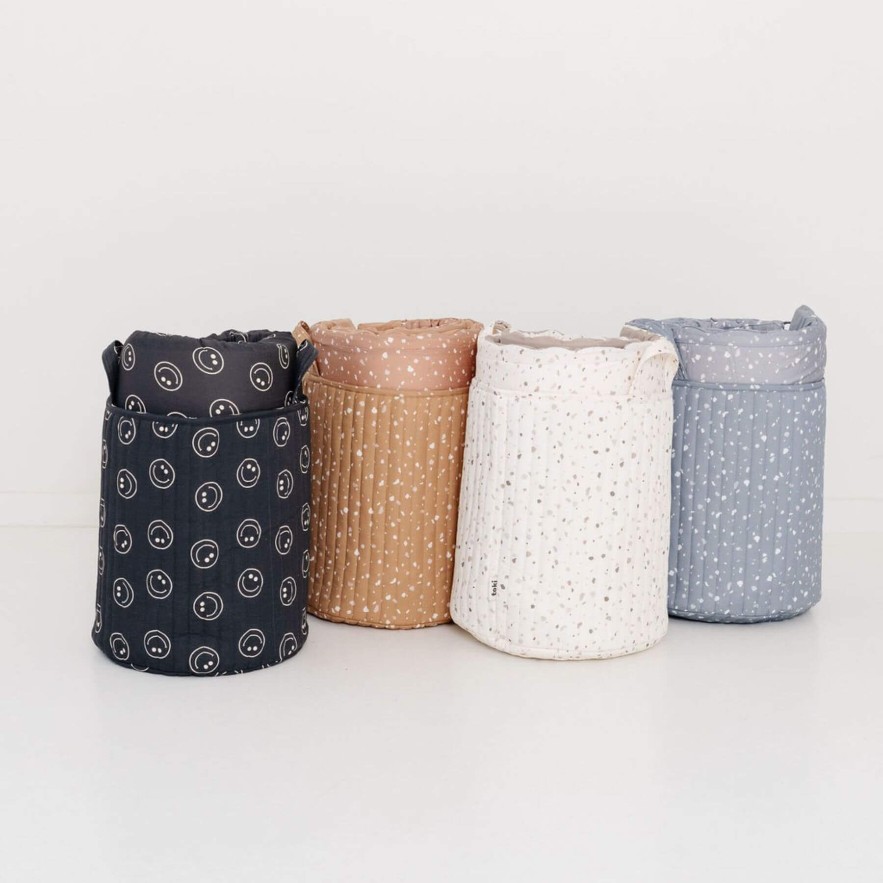 Four fabric storage bins with different patterns on a light background