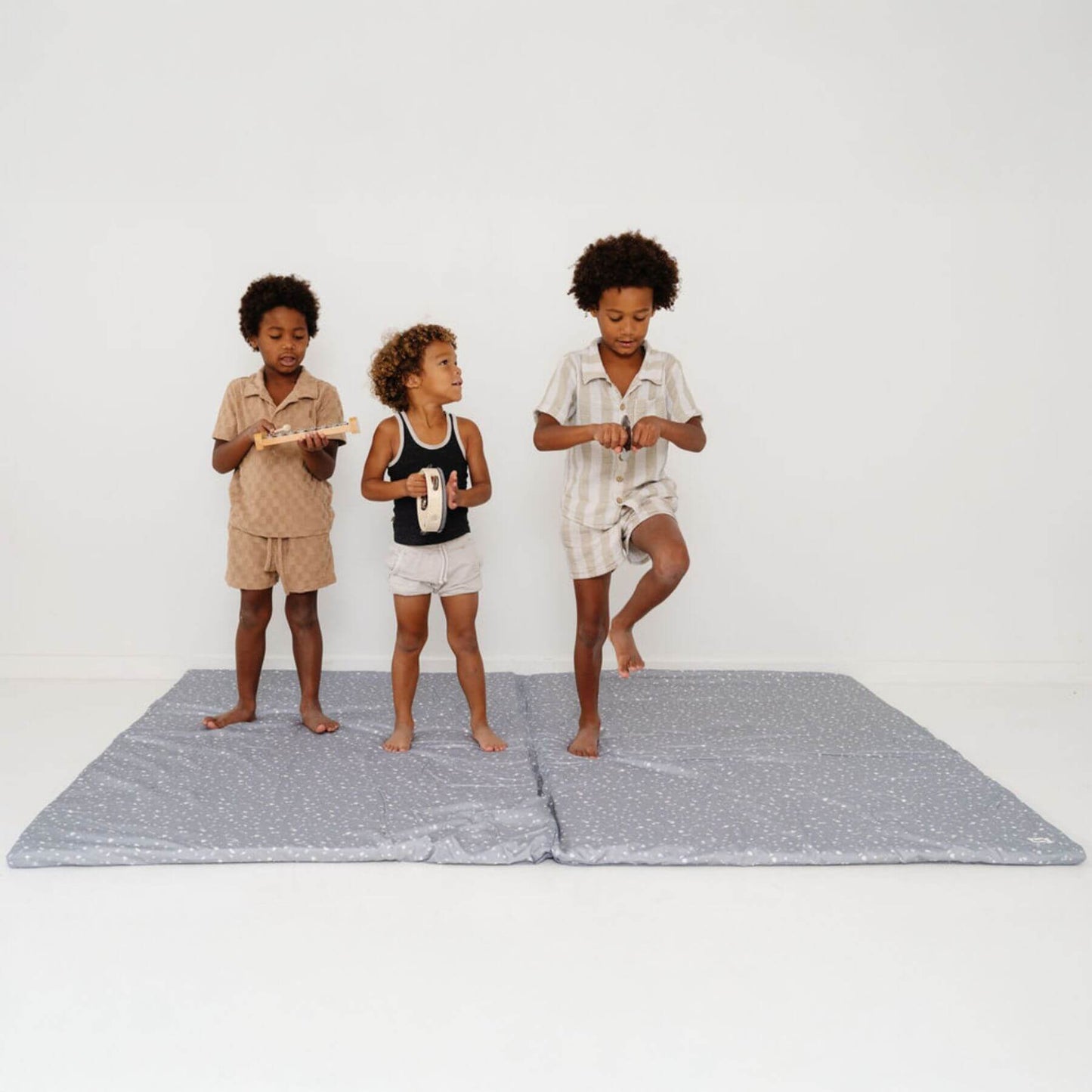 Three children standing on Terrazzo Slate Organic Cotton Mat