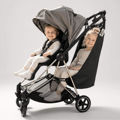 A baby stroller with The Stroller Sling - All Weather with two children sitting inside, photographed on a clean light gray studio background.